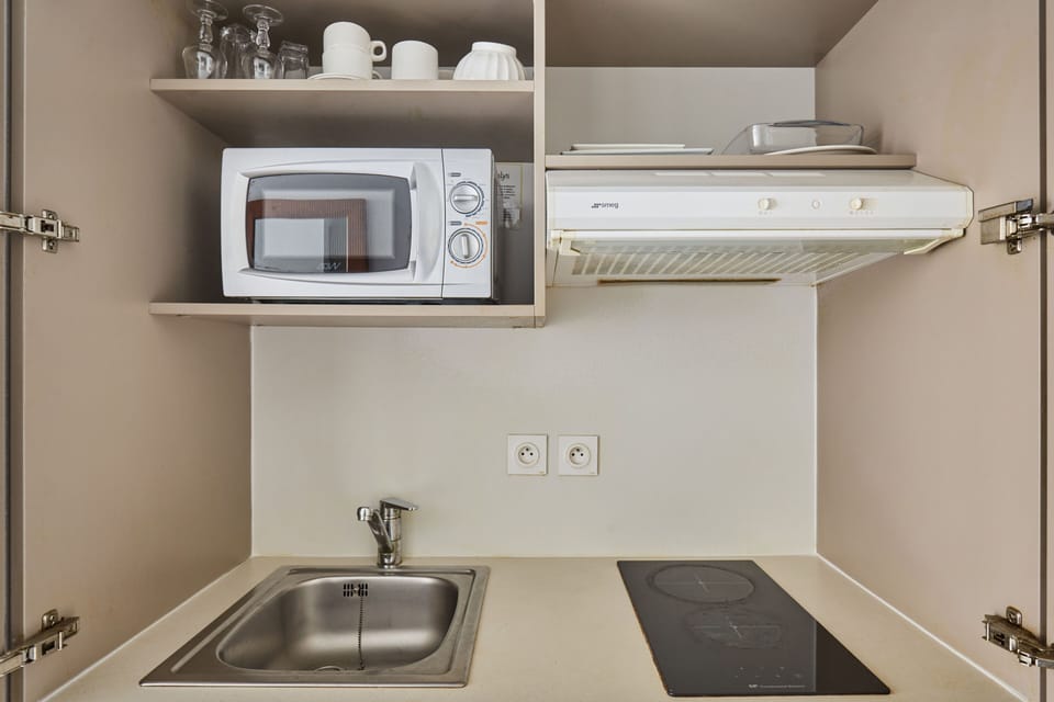 The functional kitchenette boasts essential appliances, including a microwave and stove, enabling you to prepare meals just like at home.