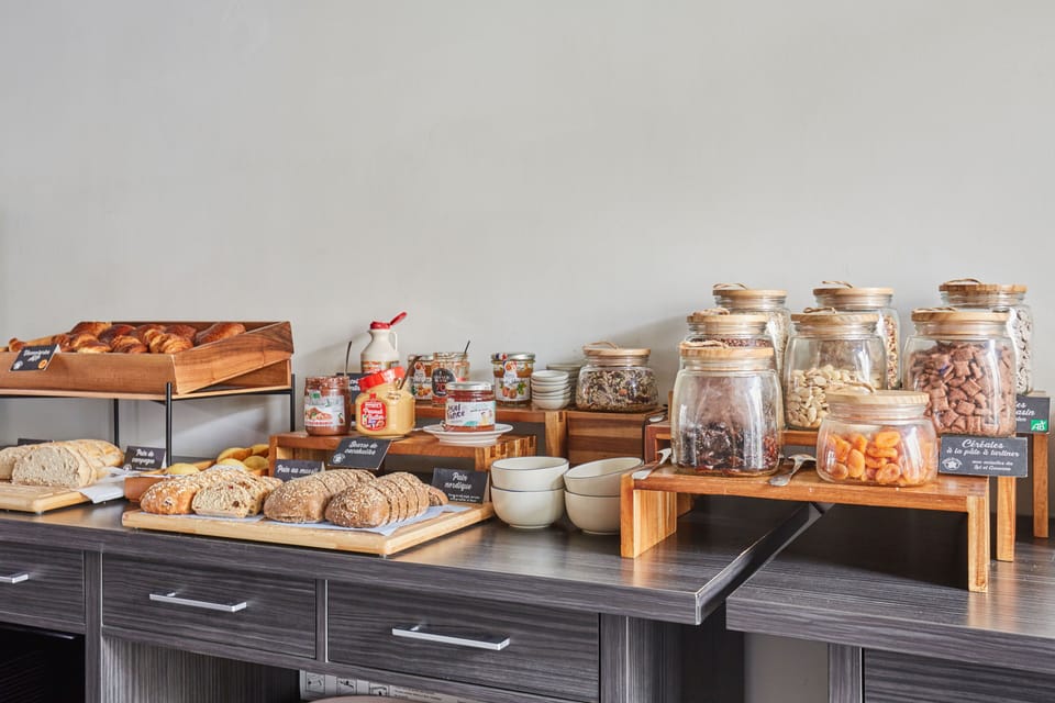 Savor the variety of baked goods and preserves at the breakfast bar, featuring local delicacies in a modern, stylish setting.