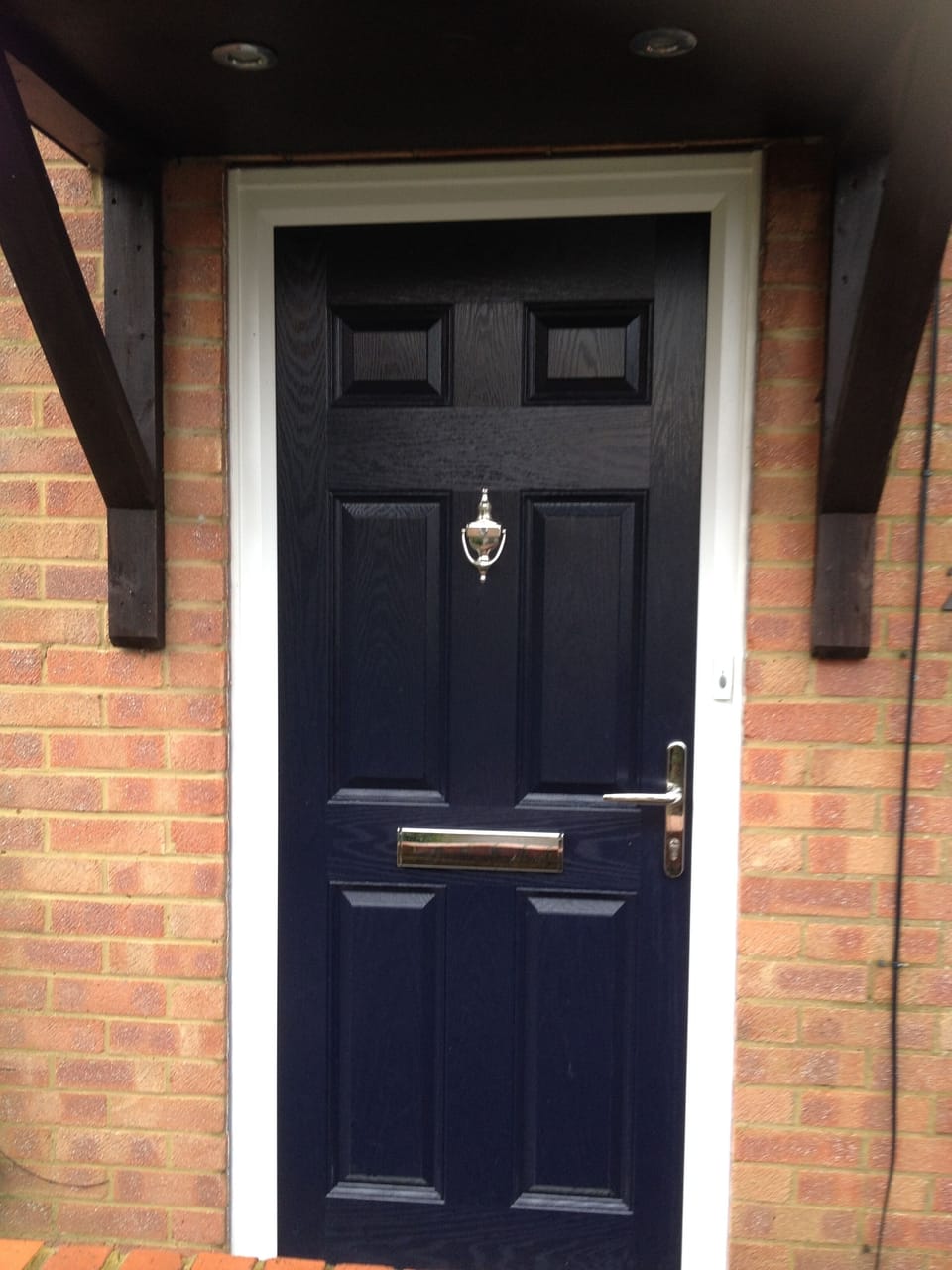Blue front door opposite a white Caravan.