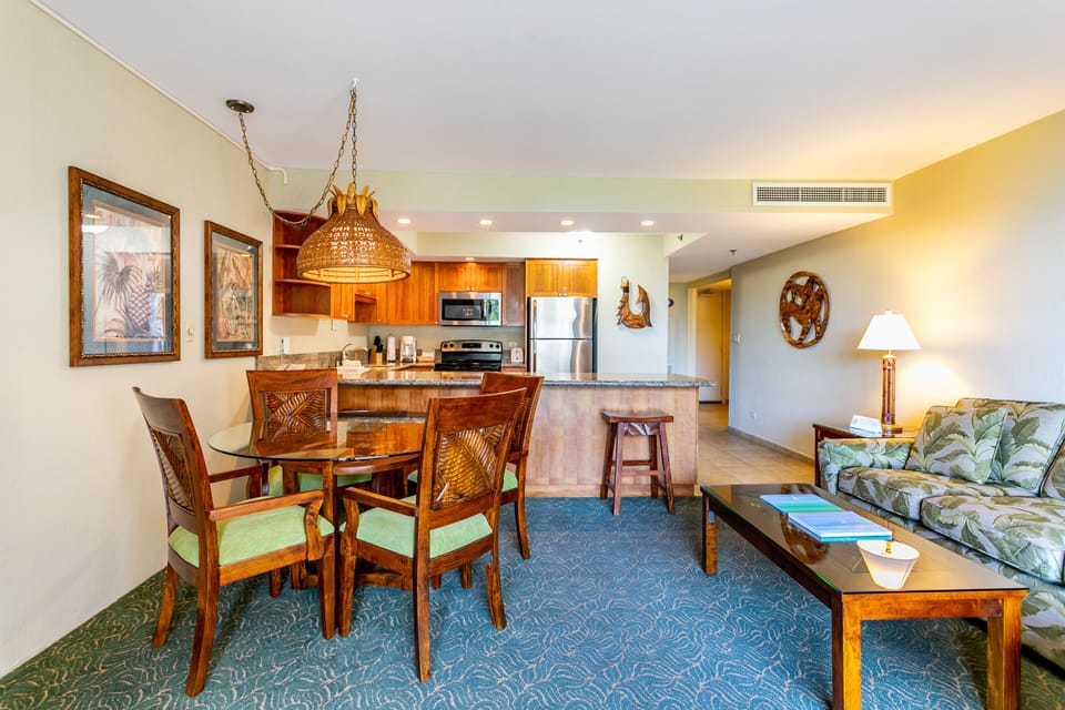 Your open-concept retreat blends tropical charm with modern comfort. Enjoy meals at the elegant dining table, unwind on the inviting sofa, and prepare island-inspired dishes in your well-equipped kitchen.
