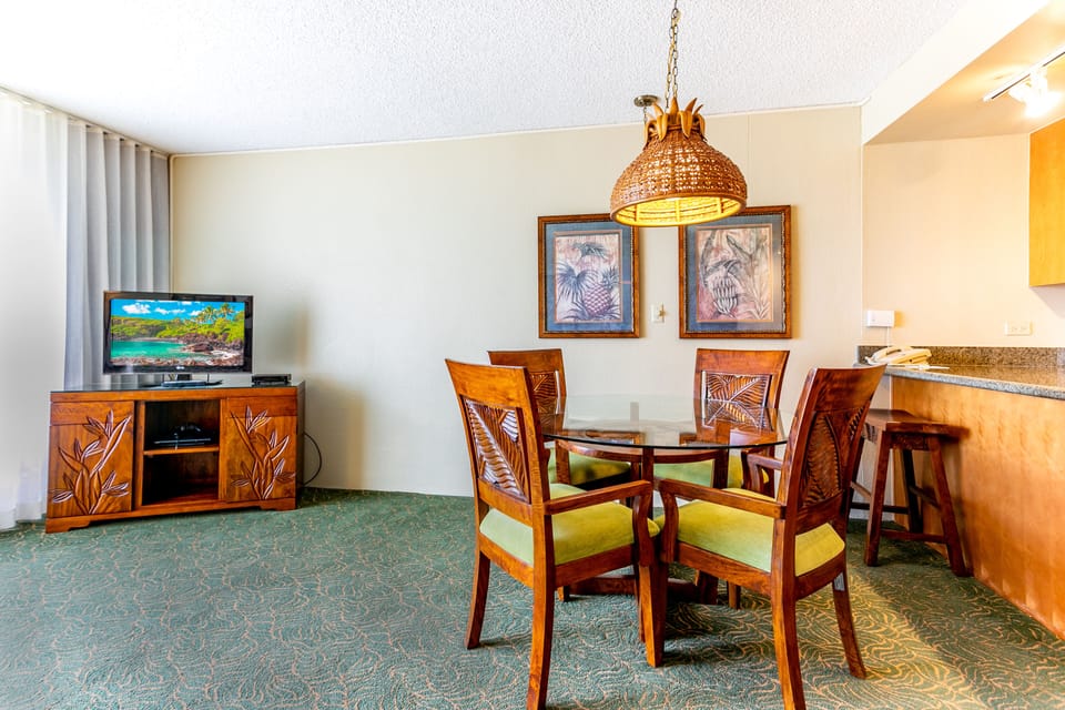 Your tropical-inspired suite invites you to unwind with warm wood furnishings, tropical artwork, and a dining area perfect for enjoying meals together in your home away from home.