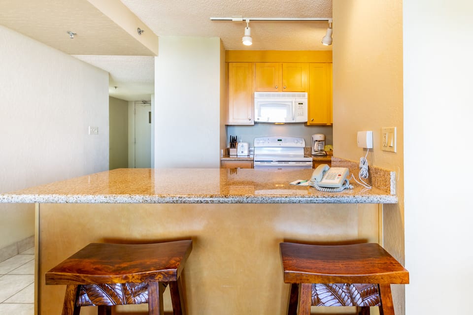 This kitchen features granite countertops, warm wood cabinetry, and updated appliances, perfect for your home-cooked meals.