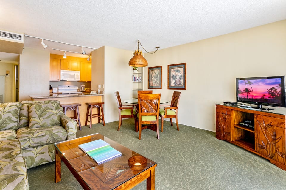 Relax in your spacious living area with tropical-inspired decor, a fully equipped kitchen, and warm wood furnishings that create an inviting island atmosphere.