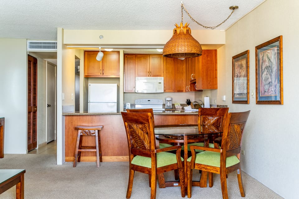 Relax at your open dining area with tropical-inspired seating and a full kitchen, perfect for preparing meals and gathering after island adventures.