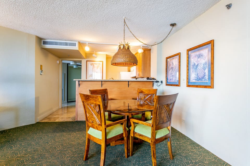 Gather around your tropical-inspired dining table where warm wood tones and island artwork set the scene for memorable meals together, all steps from your open kitchen.