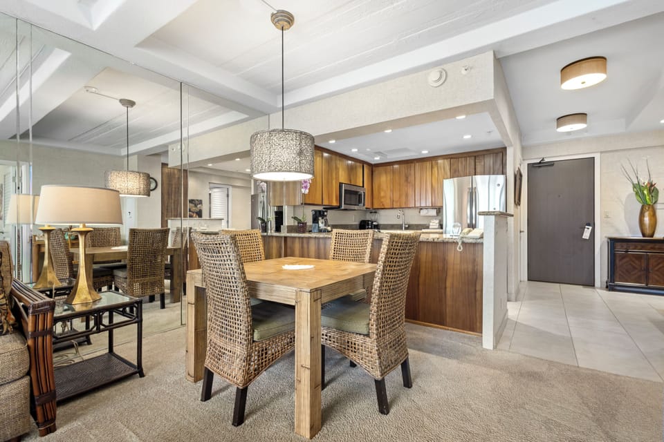 Gather around your welcoming dining table with elegant woven seating, flowing into a fully-equipped kitchen where you can create memorable meals together in this beautifully designed open space.