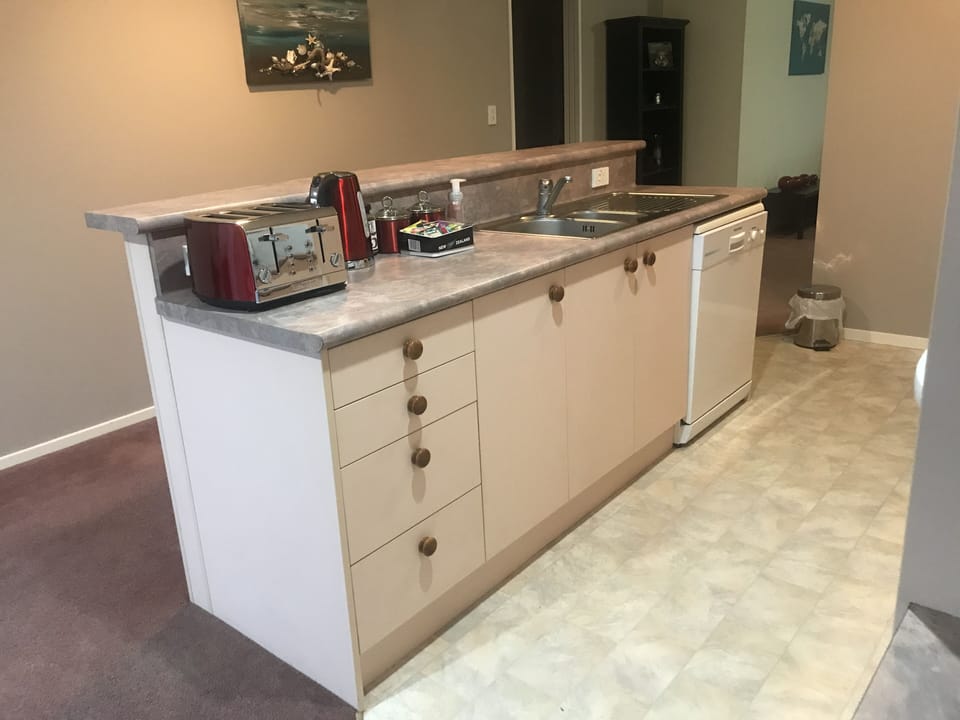 Kitchen sink island with dishwasher and cleaning products stocked