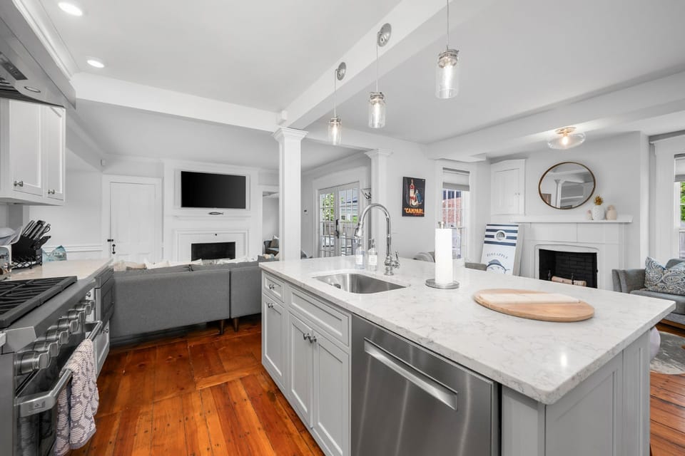 Chefs kitchen with center Island with stainless sink, 6 burner gas range and oven, microwave, open to  living area