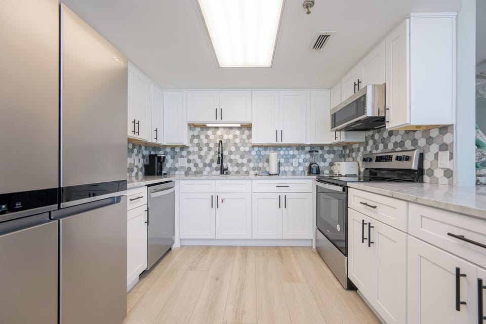 Marble counters and cool tile backsplash create a fresh space where you prepare your favorite vacation dishes