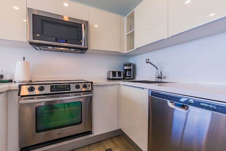 Your fully equipped kitchen offers sleek stainless-steel appliances, including a microwave, stove with oven, and dishwasher—everything you need to whip up a quick breakfast or enjoy home-cooked meals.