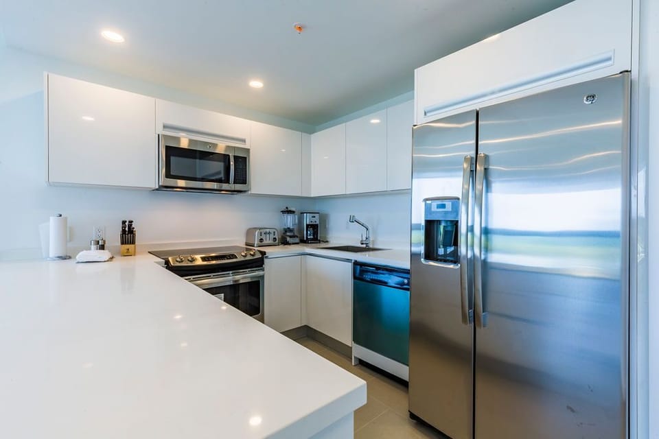 Your fully equipped kitchen features sleek stainless-steel appliances, bright white cabinetry, and ample counter space—perfect for whipping up anything from morning coffee to a full home-cooked feast.
