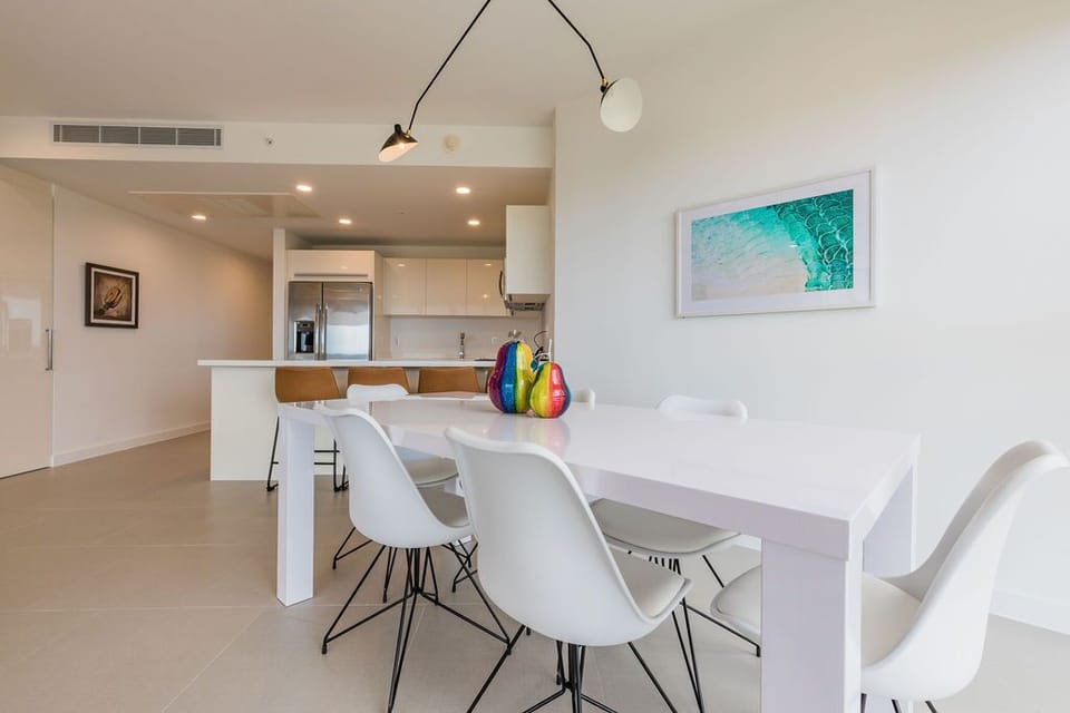 Gather around this stylish dining table where your group can share meals and stories. The open-plan layout seamlessly connects to a fully equipped kitchen, perfect for preparing your favorite dishes together.