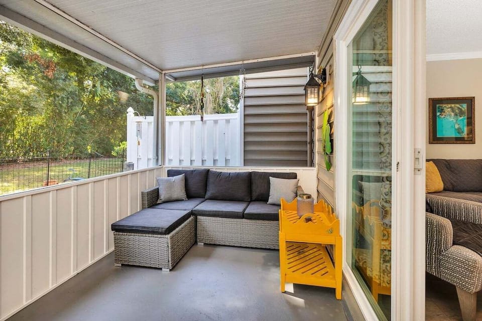 Ocean Walk M2 -Enclosed porch with sectional sofa and yellow accent chair