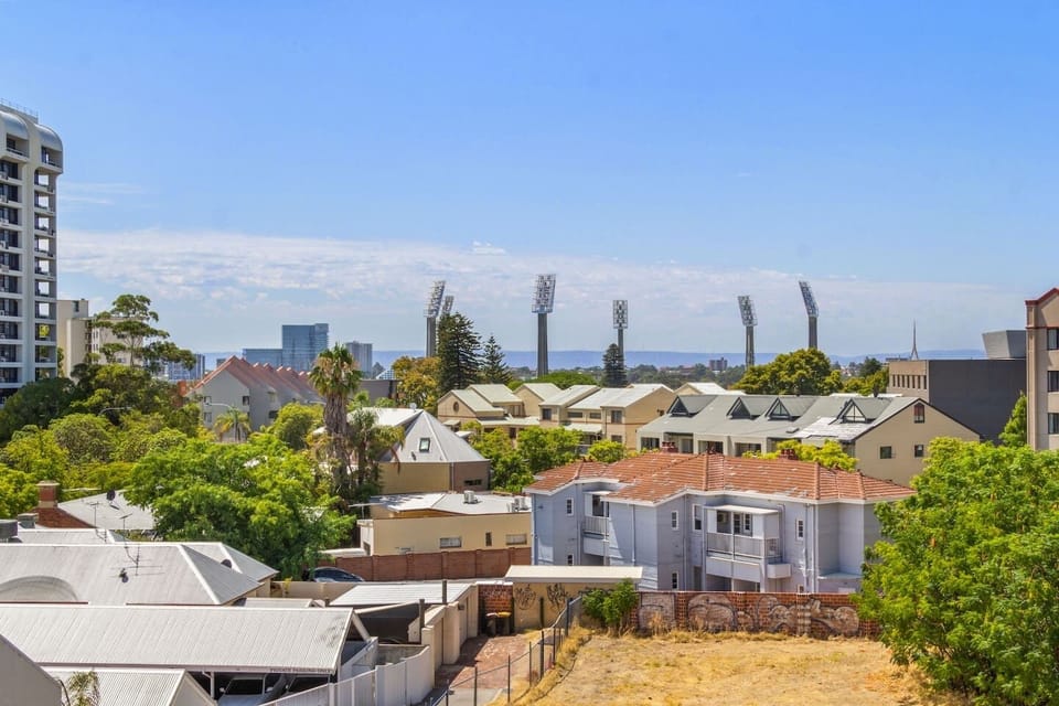 Captivating outlook over a charming neighbourhood with a glimpse of the city and stadium lights in the distance.