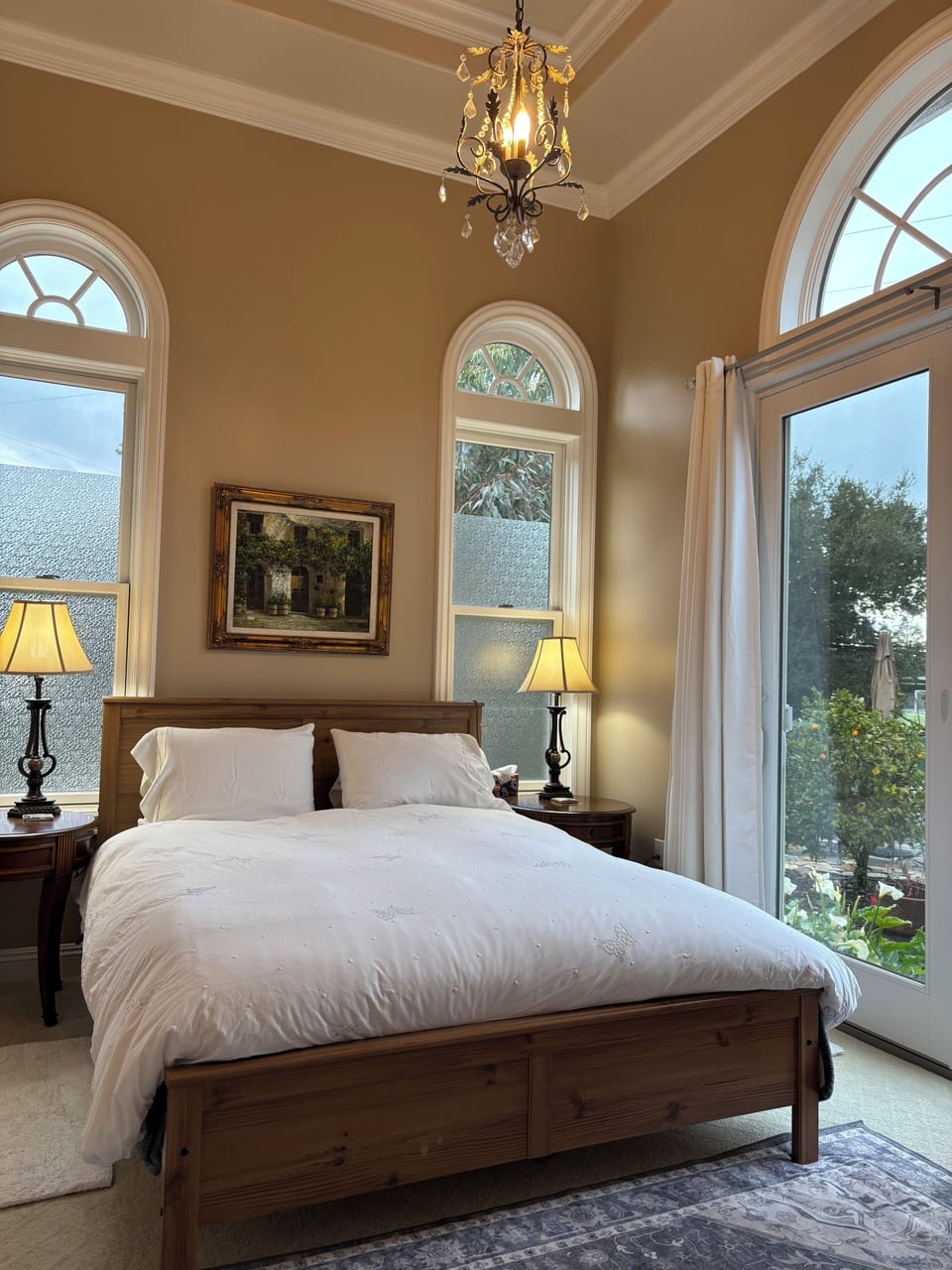 Bedroom 1 with queen sized bed.  12’ tall Celing.  Patio door leads to side yard