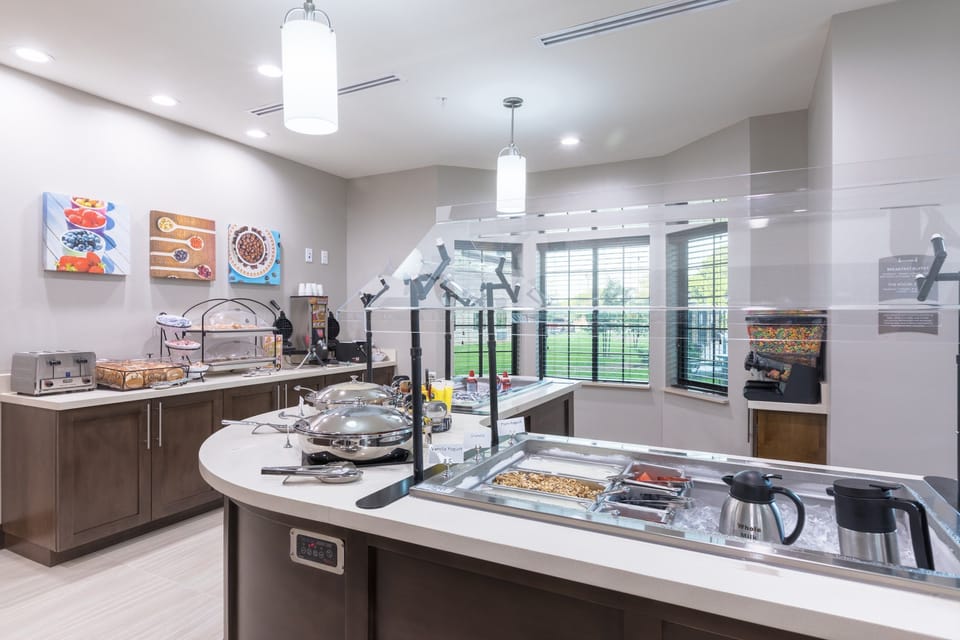 Breakfast buffet with food options and decorative wall art.