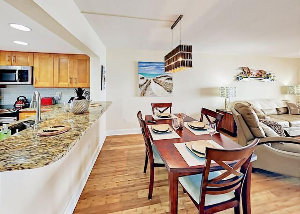 The formal open-concept dining area seats four at a polished wood table