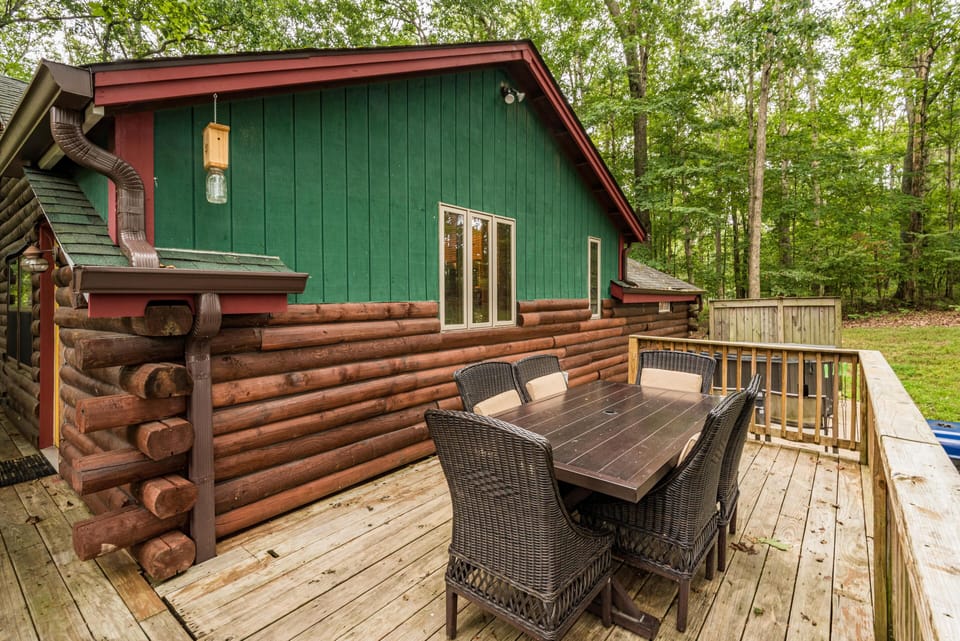 Outdoor dining area with dark wicker chairs and wooden table on the deck