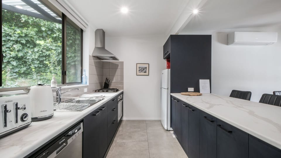 Kitchen with large kitchen bench and four stools