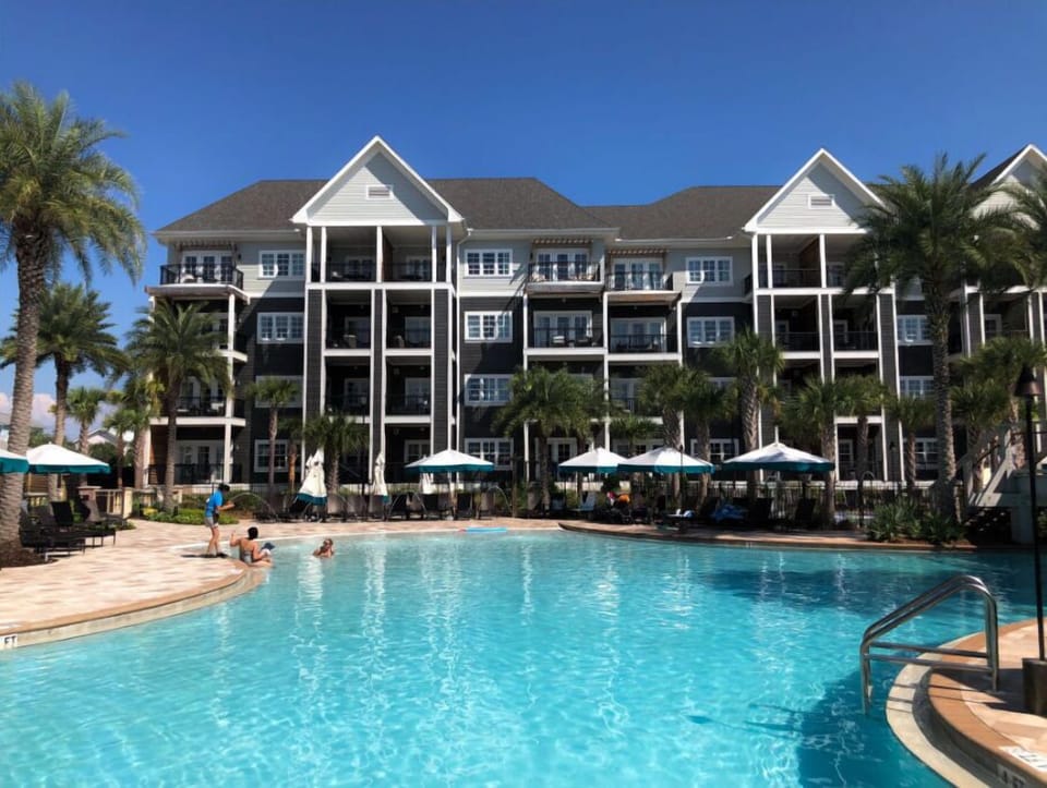A spacious resort pool flanked by palm trees, offering a refreshing escape.