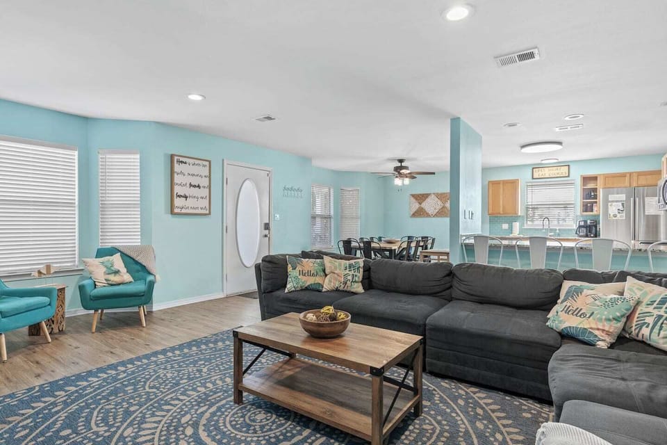 Large living room open to the kitchen and dining area with 65" Smart TV and arcade