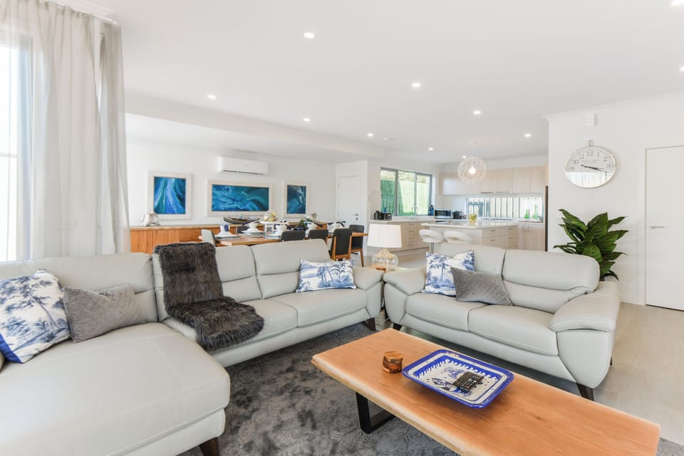 Opening plan living area with couches, dining and kitchen