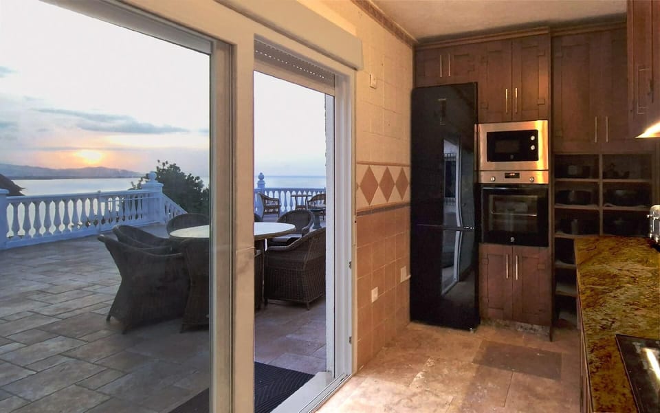 Kitchen from other side with view of terrace and sea