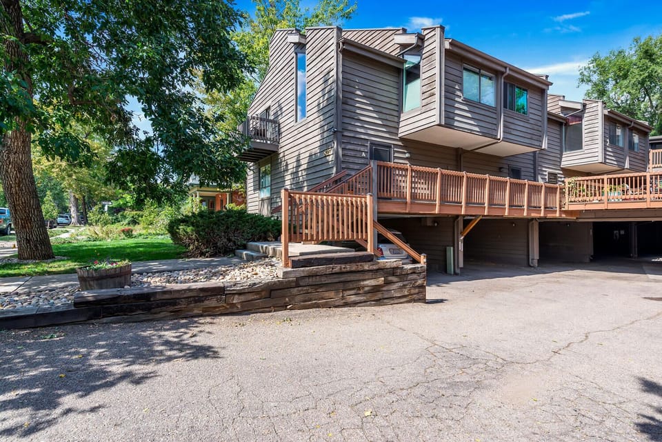 Front unit with windows on 3 sides and 2 car carport directly underneath unit.