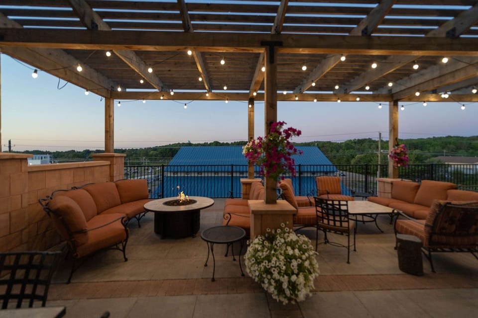 Evening outdoor lounge with fire pit seating and decorative lighting.