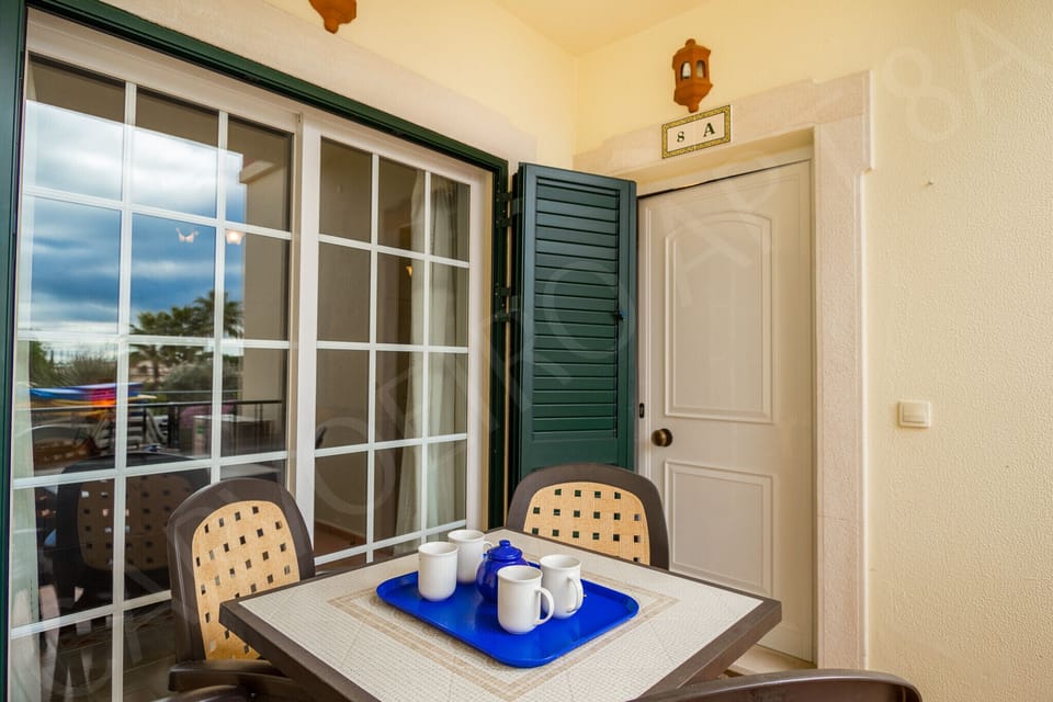 Private terrace at Carvoeiro Apartment 8A with outdoor table and chairs, perfect for morning coffee with views over the gated complex gardens near Carvoeiro in the Algarve