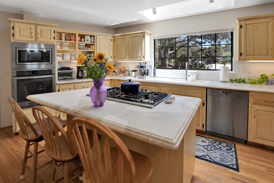 Chef's kitchen with marble counters, espresso machine, and gas stove & oven