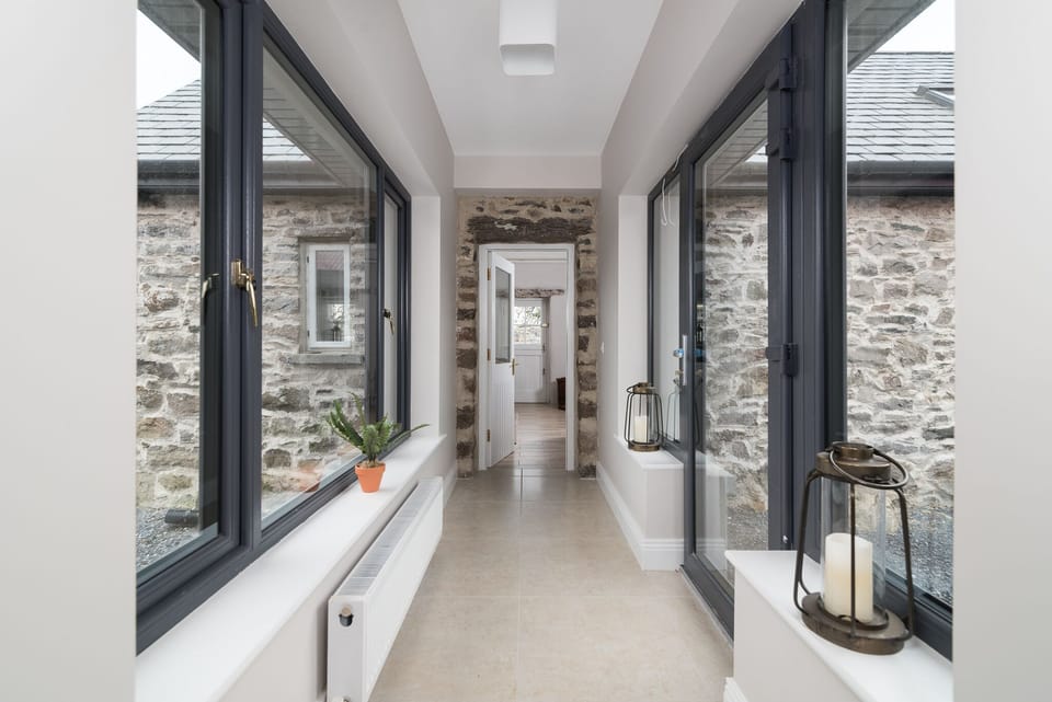 Light-filled passageway linking old and new  in Teách Titanic (Titanic Cottage)