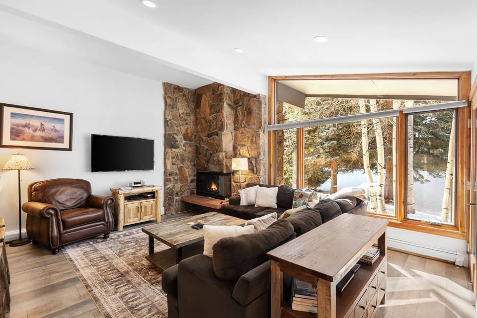 This bright living room with high ceilings and wood burning fireplace is the perfect place to relax after skiing or hiking in Snowmass