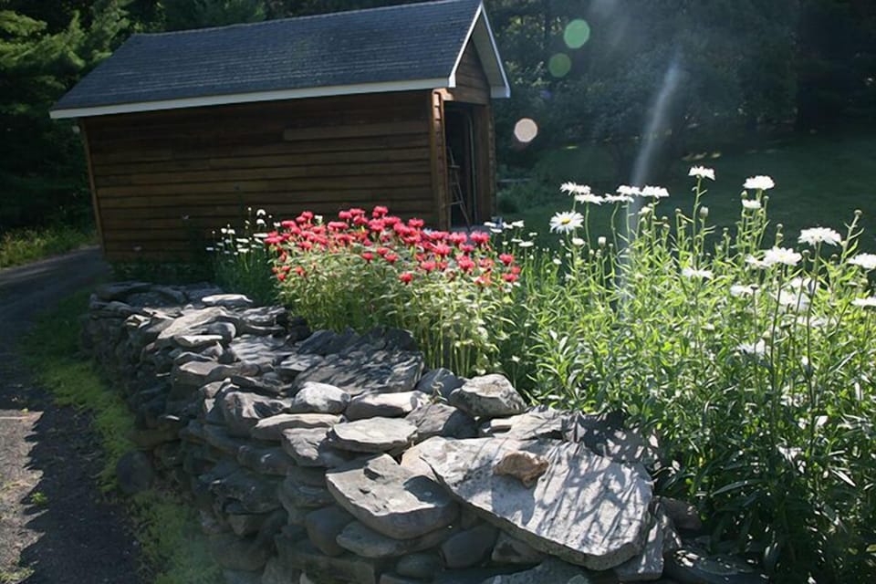 Enjoy the sweet fragrance of multiple flower beds and stone walls.