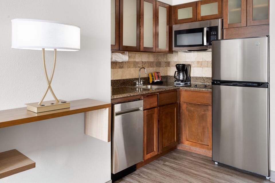 Modern kitchenette with stainless steel appliances and granite countertops.