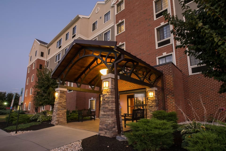 Welcoming entrance featuring a cozy seating area and lush landscaping.