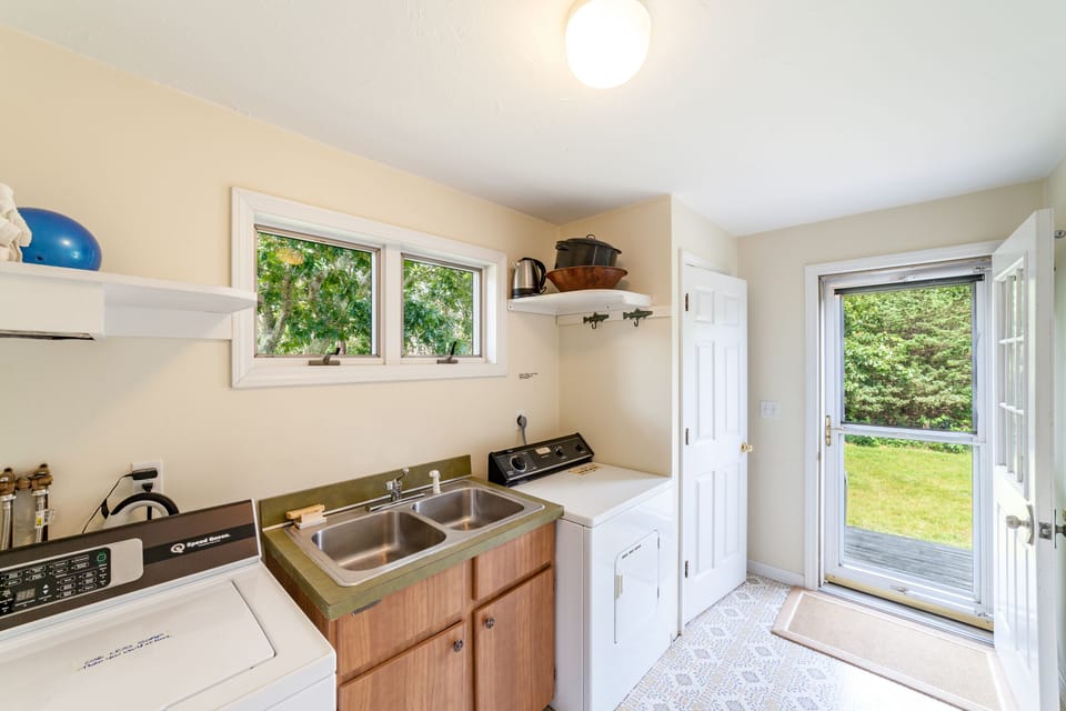 Laundry off kitchen with washer, dryer, half bath & side door to outside shower