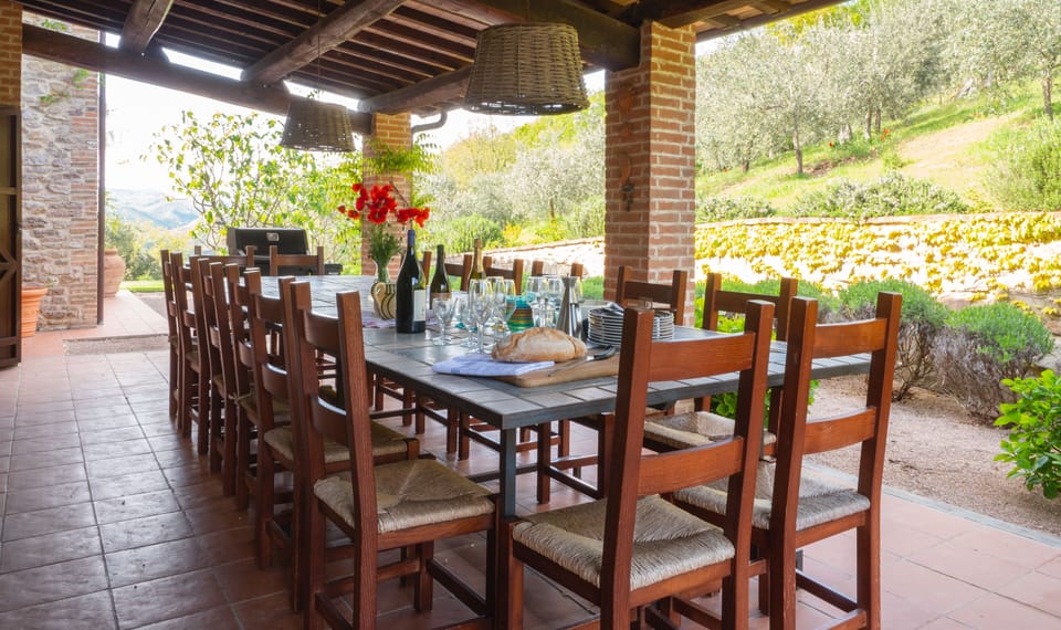 Shaded outdoor dining with the BBQ at the end. 