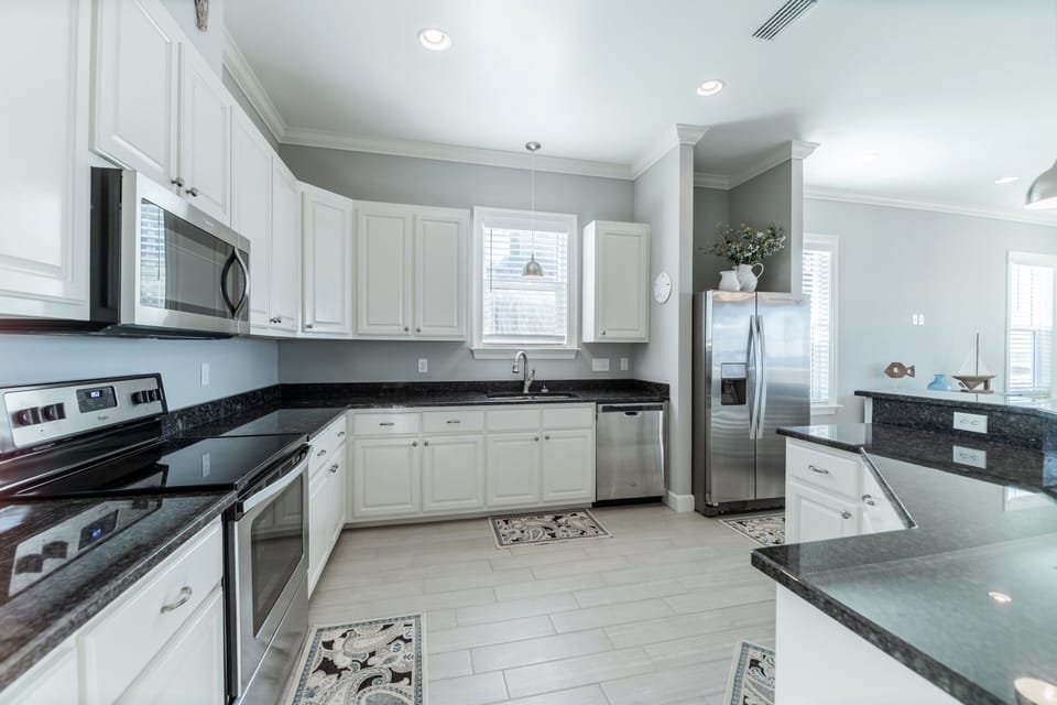 Fully equipped coastal kitchen featuring stainless steel appliances, granite countertops, and ample cabinet space. Perfect for preparing family meals or fresh seafood during your Dauphin Island getaway.