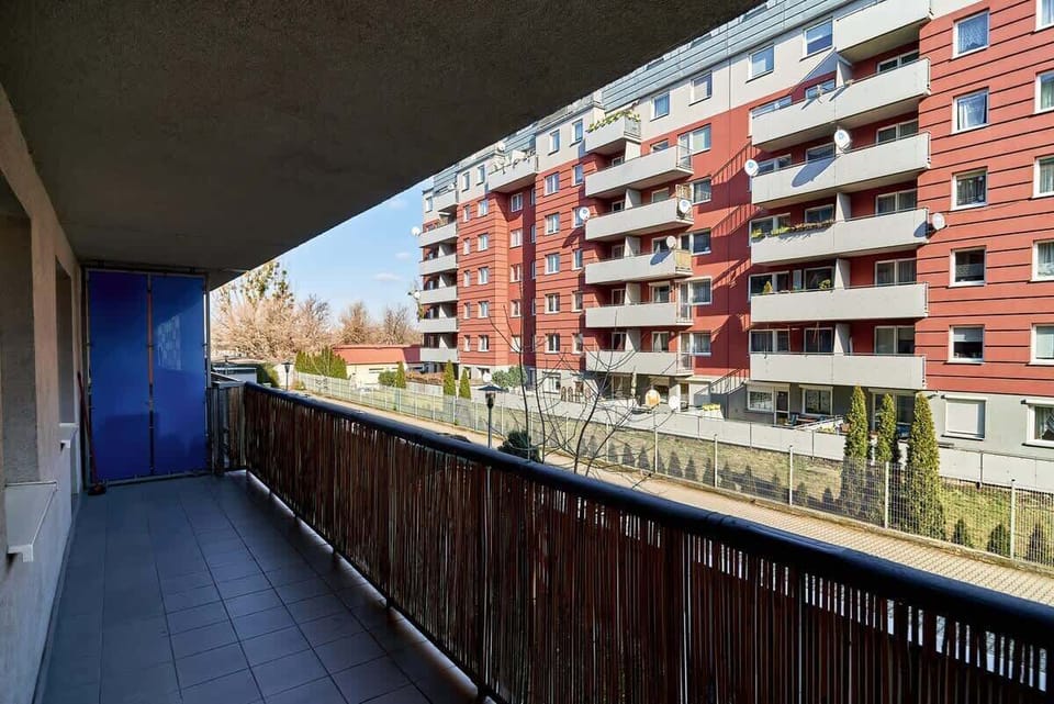A view of a residential area from a balcony. There are multiple buildings visible, all with a modern, urban style.

