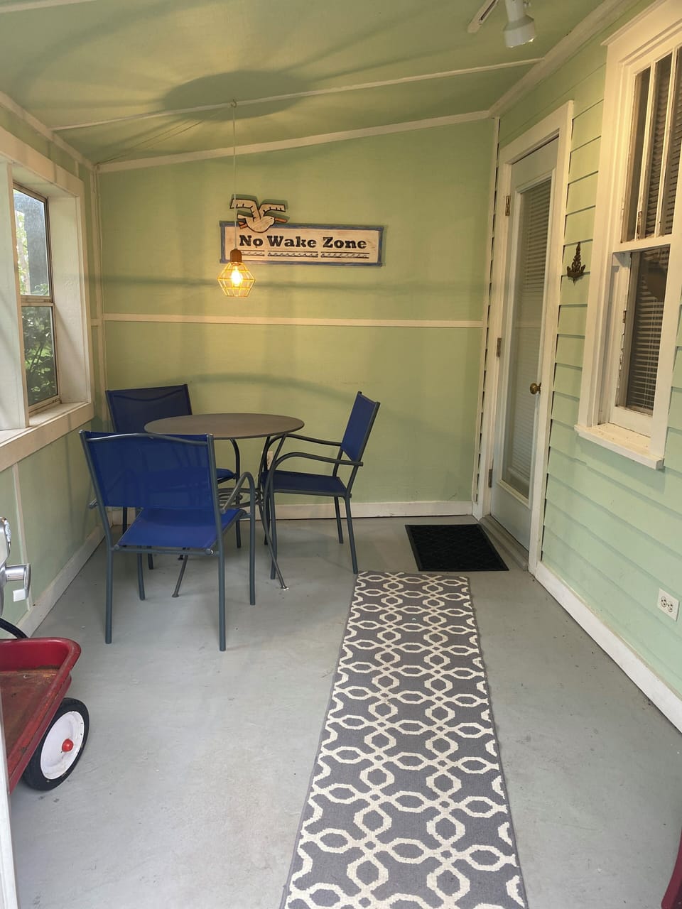 Main entrance front porch. Table and chairs for morning coffee. Plus beach wagon