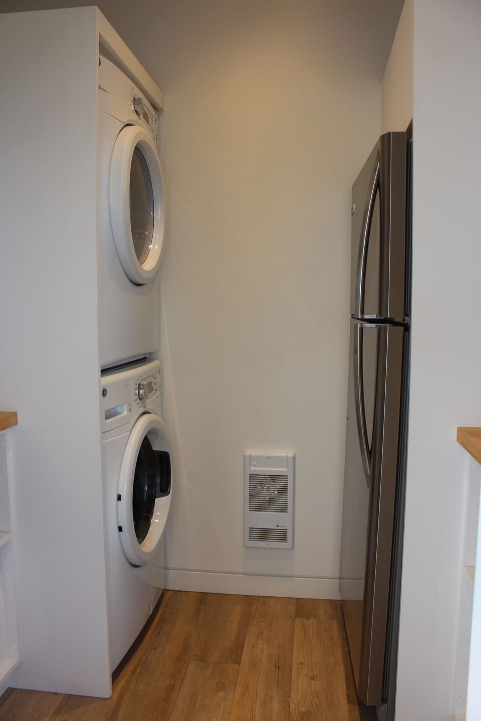 The fridge and laundry area that is in the pantry