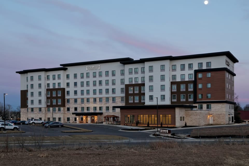 Building exterior at dusk with illuminated entrance sign.