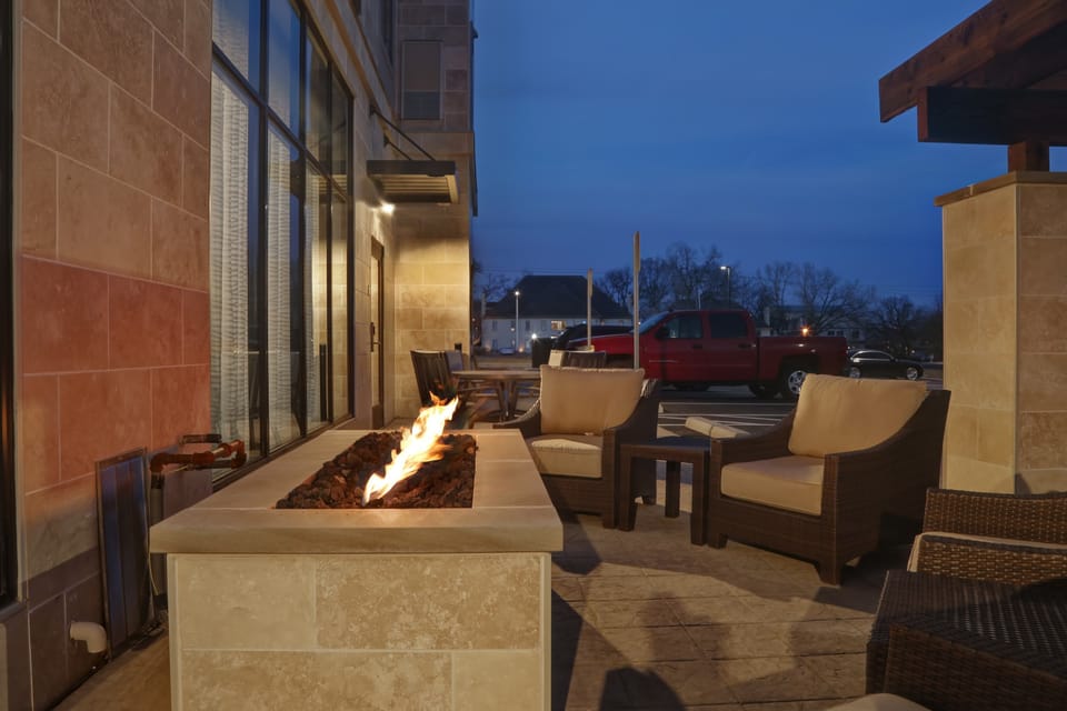 Outdoor patio with fire pit and comfortable seating at dusk.