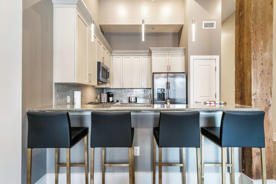Cook and dine easily in the fully stocked kitchen, equipped with all stainless steel appliances, gas range, basic cookware, and a dining area for a comfortable meal at home. Entertain at the bar with seating for four.