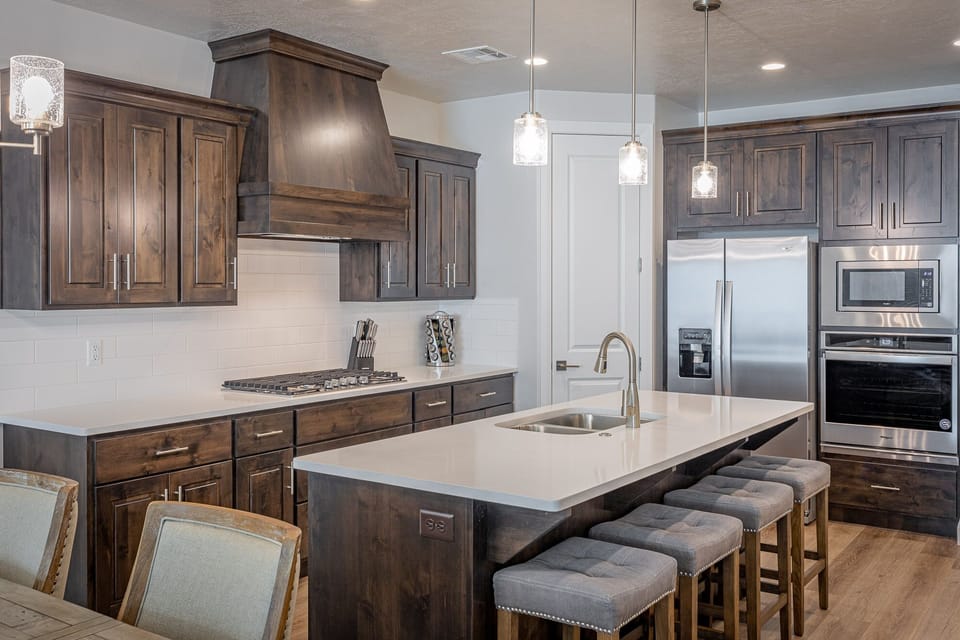 Kitchen Island - Side view of kitchen showing off the beautiful counter tops and stainless-steel appliances.