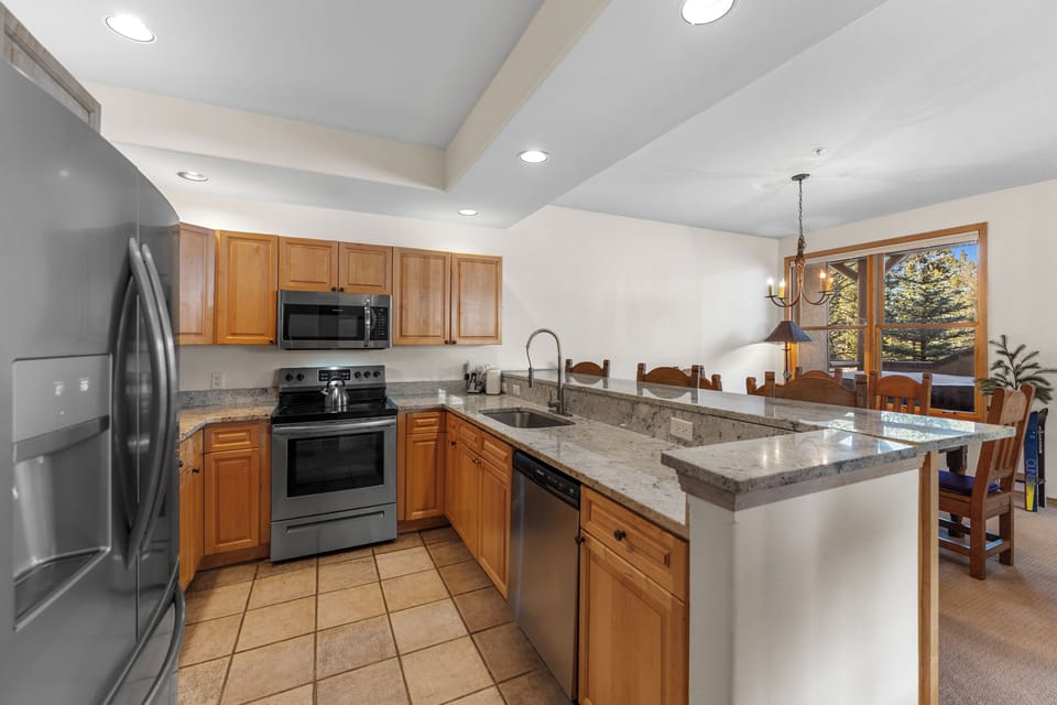 Full kitchen offering stainless steel appliances throughout and breakfast bar with seating for three