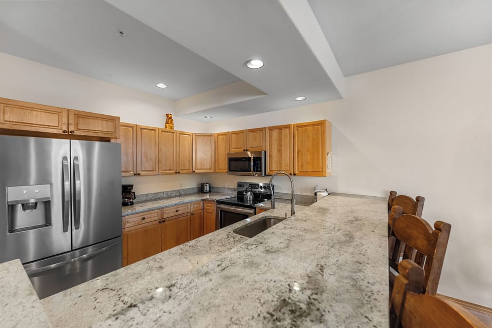 Full kitchen offering stainless steel appliances throughout and breakfast bar with seating for three
