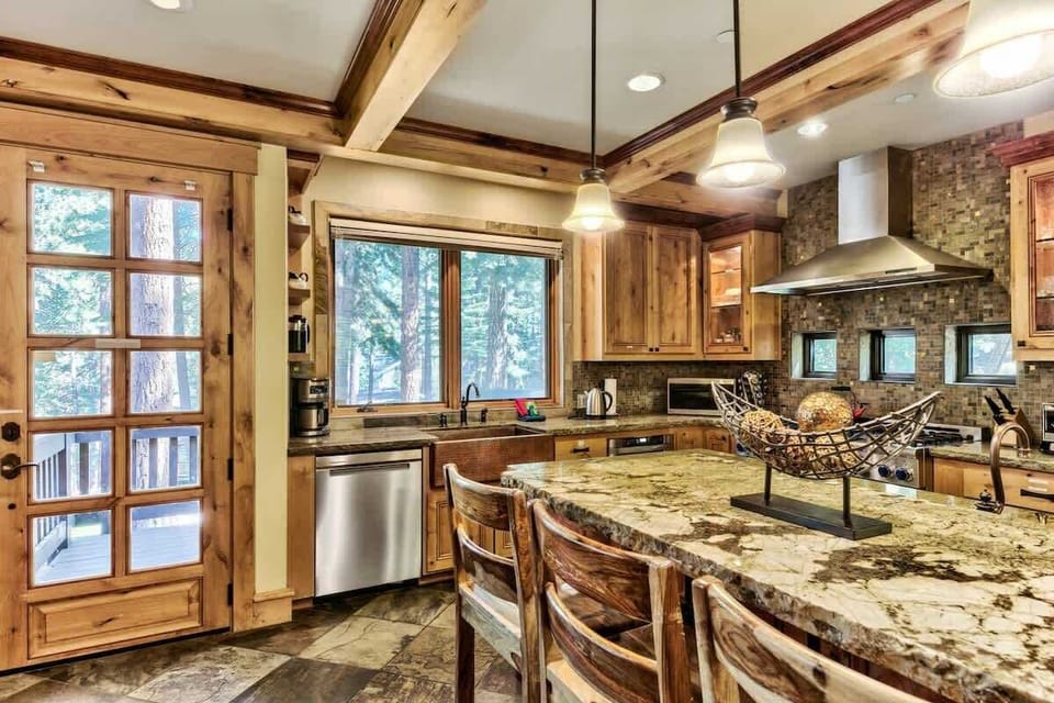 Open kitchen and dining layout keeps the group together. High-end appliances, cookware, dinnerware and a large island provide everything needed to comfortably cook for larger groups.