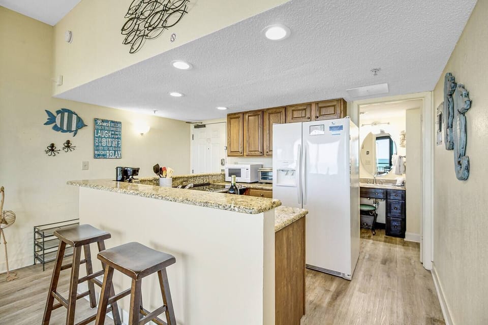 Step into a seaside culinary retreat in our oceanview suite's kitchen, where sleek appliances, coastal-inspired decor, and panoramic views create an inviting space for culinary creativity.